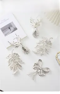Silver reindeer head and cutout leaf Christmas ornaments with white hanging strings
