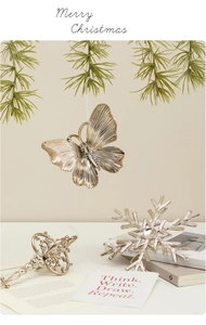 Detail of champagne gold Christmas ornaments including metal butterfly and snowflake pieces