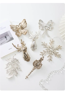 Detailed view of champagne gold and silver metal Christmas ornaments with reindeer and snowflake