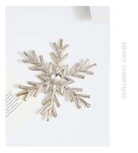 Close-up of a silver metal snowflake ornament with a polished finish for Christmas decor