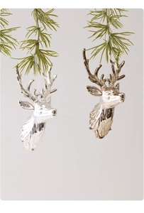 Close-up of reindeer head Christmas ornaments in silver and gold hanging on tree branches
