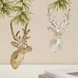 Brown reindeer head Christmas ornaments in gold and silver hanging on pine branch