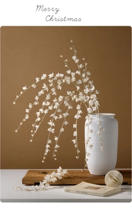 Detail of white artificial Christmas branch with pearls in a ceramic vase decoration