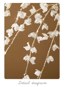 Macro detail of white pearlescent floral ornament with gold wire and clear beads