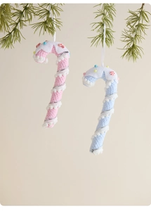 Nahaufnahme von pastellfarbenen Plüsch-Zuckerstangen mit Waffelstruktur am Tannenzweig