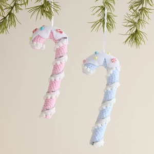 Rosa und blaue Flanell-Zuckerstangen mit Waffelstruktur an grünen Kiefernzweigen