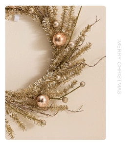 Detail of champagne gold Christmas wreath with glossy and matte ornaments and lettering