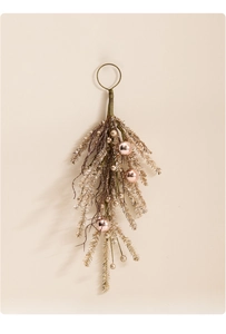 Close-up of champagne gold pine needles and pink ornaments on a holiday decorative swag