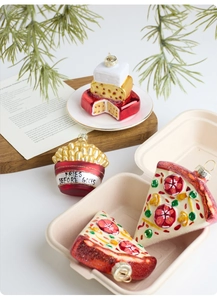 Detail of pizza and fries glass Christmas ornaments on a white festive background