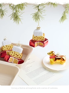 Detailed view of glass Christmas ornaments featuring cake and golden dog tree decorations