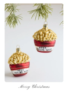 Close-up of French fries Christmas ornament with Fries Before Guys text on green pine branch