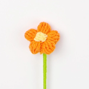 Dettaglio di un fiore a sbuffo da 4cm lavorato all'uncinetto con petali arancioni e cuore giallo