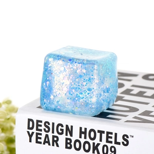 Close-up of blue glitter ice cube squeeze toy showing translucent texture and sparkles