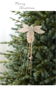 Detailed cream hummingbird ornament with pearls and sequins hanging on a Christmas tree