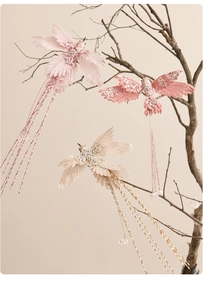 Close-up of handmade hummingbird ornaments with sequins and beads on branches