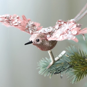 Pink fabric Christmas hummingbird ornament with rose gold glitter and sequins on pine branch
