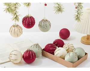 Detalle de bolas de Navidad de 8cm en terciopelo con lentejuelas y flecos en mesa festiva