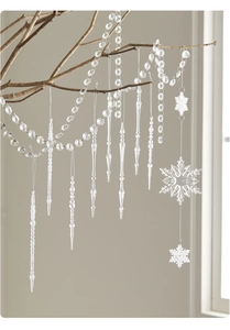 Vista de copos de nieve y carámbanos de acrílico transparente colgados en ramas secas