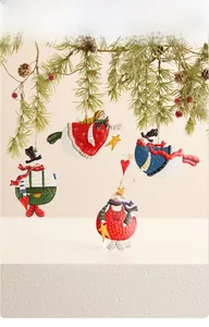Hand-painted vintage snowman metal ornaments hanging on a festive pine tree branch