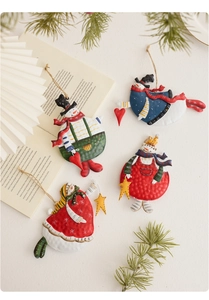 Detail of four colorful vintage hand-painted metal snowman ornaments with rustic jute ropes