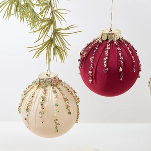 Bolas de Navidad de terciopelo granate y crema con lentejuelas en ramas de pino