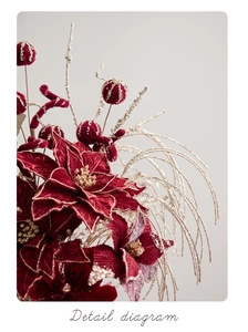 Detail of burgundy poinsettia with gold glitter edges and festive red berry stems