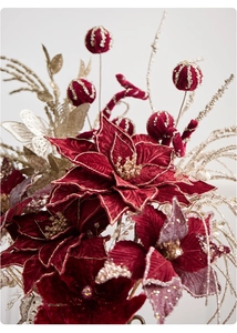 Close-up of velvet poinsettia with gold glitter edges and festive beaded ornaments