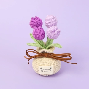 Detail of handmade crochet purple tulip in a beige knitted pot with a handmade label