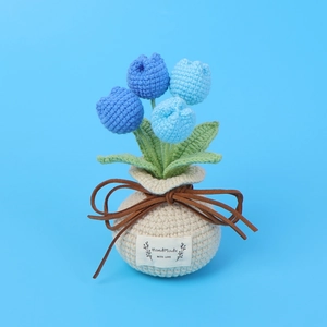 Detail of handmade crochet blue tulip potted plant with a woven gift bag base