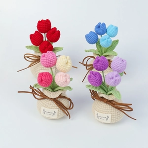 Detail of handmade crochet tulip potted plants with heart tags and leather bows