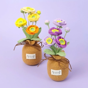 Detail of handmade crochet poppy flower potted plants with brown woven base and labels