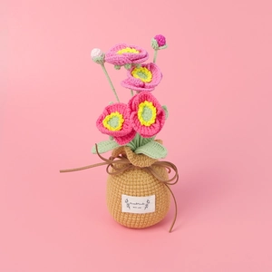 Macro shot of handmade crochet poppy flower in pot with a Handmade With Love label