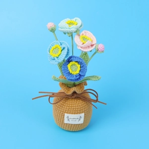 Close-up of handmade crochet poppy flowers with a 'Handmade WITH LOVE' tag on the pot