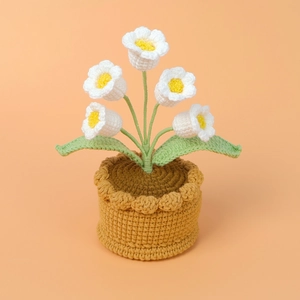 Handmade crochet Lily of the Valley potted plant with yellow flower core and green leaves