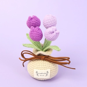 Handmade crochet purple tulip bouquet in a beige woven pot with a decorative leather bow