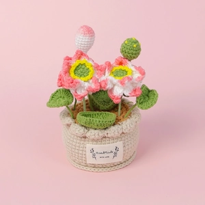 Detail of hand-crocheted lotus bonsai with pink flowers and a Handmade With Love label