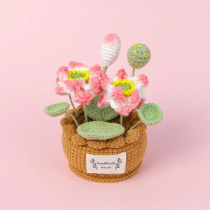 Detailed handmade crochet lotus flower pot with blooming pink petals and green leaf