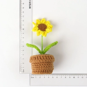 Detailed view of handmade crochet sunflower pot showing dimensions with a clear ruler