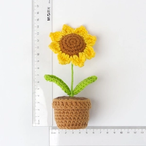 Detailed view of handmade crochet sunflower pot with dimensions shown on a ruler