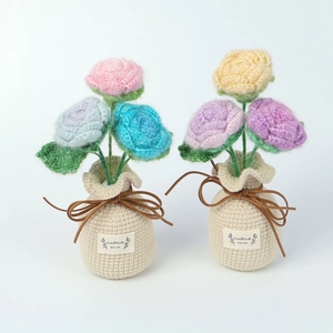 Detailed close-up of handmade crochet flower pot with three colorful knitted roses