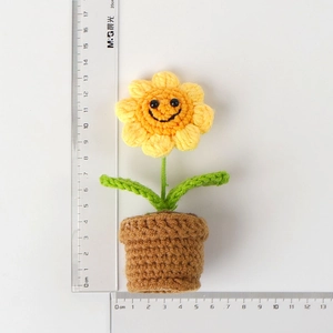 Detail shot of crochet sunflower potted plant with measurements showing height and width
