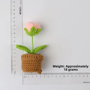 Macro shot of handmade crochet forget-me-not flower pot showing 14cm height on a scale