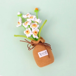 Handmade crochet daffodil potted plant with white petals and yellow centers in a knit pot