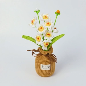 Detailed texture of handmade crocheted narcissus in a brown pot with a handmade label