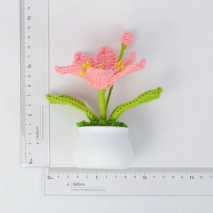 Handmade pink crochet flower pot plant measuring 12.5cm height on white background