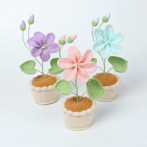Détails de trois pots de fleurs au crochet faits main en laine violette, rose et bleue