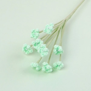 Detailed view of handmade crochet flowers with small pearls on green stems