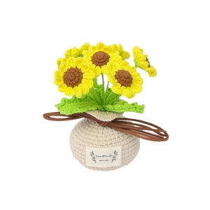 Handgefertigte gehäkelte Sonnenblume im Topf mit grünen Blättern und beigem Sockel