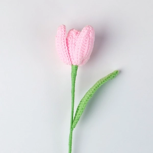 Detail of handmade crochet pink tulip with fine knitting texture and green stem