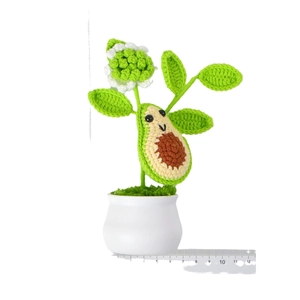 Handmade crochet avocado potted plant with smiling face in a white ceramic vase